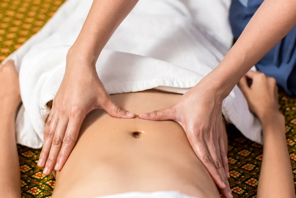 a close up shot of a tcm therapist's hand doing a tcm postnatal massage to a new mother in Singapore